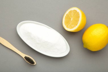 Tahta bambu çevre dostu diş fırçaları, gri arka planda kabartma tozu. Diş bakımı ve sıfır atık konsepti. Üst görünüm