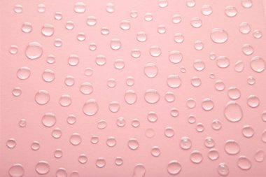 Su damlaları pembe arkaplanda. Üst görünüm