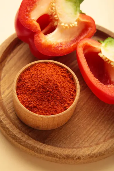 Bej arka planda taze kırmızı biberli paprika tozu. Dikey fotoğraf. Üst görünüm