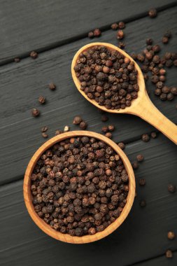 Ahşap kasede siyah biberli mısır ve siyah ahşap arka planda kaşık. Üst görünüm