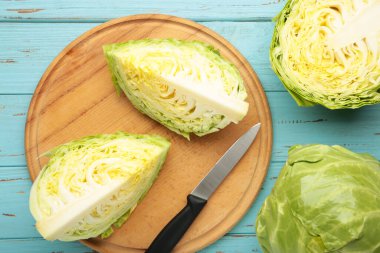 Mavi ahşap arka planda kesilmiş lahanalar. Üst görünüm