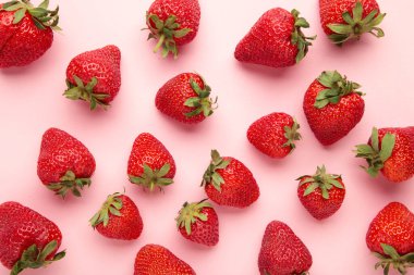 Pembe arka planda kırmızı çilek. Makro fotoğraf. Üst görünüm