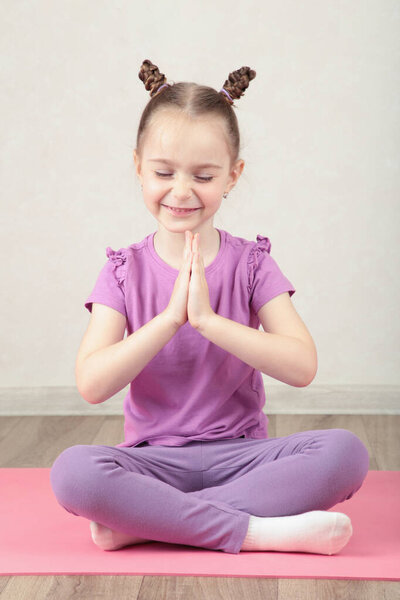 Маленькая милая девушка практикующая йогу поза на светлом фоне. Вид сверху