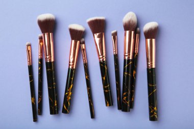 Mor arka planda makyaj için fırça seti. Üst görünüm