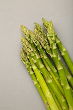 Gri arka planda taze yeşil kuşkonmaz. Sağlıklı gıda konsepti. Vejetaryen sağlıklı yemek. Üst görünüm