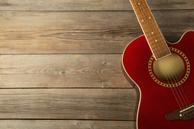 Gri ahşap arka planda kırmızı gitarın ayrıntıları. Mesaj için yer var. Üst görünüm