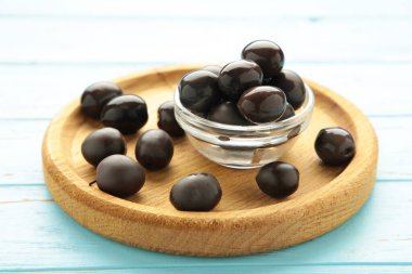 Mavi ahşap kaplama ahşap tabakta limonlu siyah zeytin. Üst görünüm