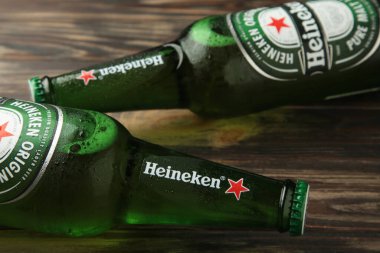 Mykolaiv, UKRAINE - Temmuz 2024: Kahverengi ahşap arka planda bir şişe Heineken Lager Birası.