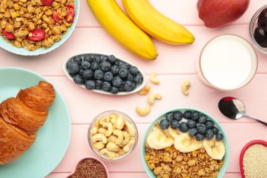 Pembe arka planda sağlıklı kahvaltı. Taze böğürtlenli granola. Üst görünüm