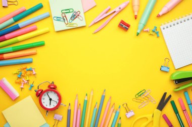 Okul malzemelerinin sarı arka plandaki stüdyo görüntüleri. Üst görünüm