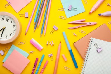 Okul malzemelerinin sarı arka plandaki stüdyo görüntüleri. Üst görünüm