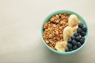 Yulaf üzümlü granola ve taze yaz meyveleri kasede, üst manzara. Sağlıklı kahvaltı yemeği kavramı