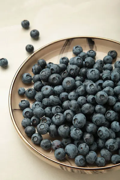 stock image Beige ceramic bowl of fresh ripe blueberries on light background. Space for text