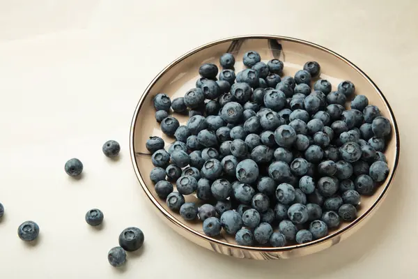 stock image Beige ceramic bowl of fresh ripe blueberries on light background. Space for text