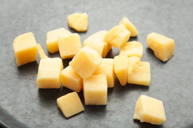 Koyu arkaplanda peynir küpleri. Parmesan peyniri. en üstteki görünüm