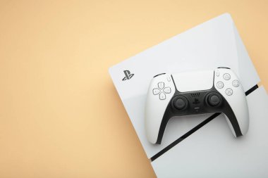 Mykolaiv, UKRAINE - Temmuz 2024: Beyaz konsol PlayStation 5 ve bej arka planda oyun alanı