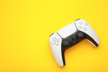 Mykolaiv, UKRAINE - Temmuz 2024: Sony 'den yeni ürün, sarı arka planda oyun alanı, oyun denetleyici