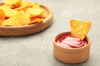 Kasede nachos ve gri arka planda ketçap. Meksika yemeği.