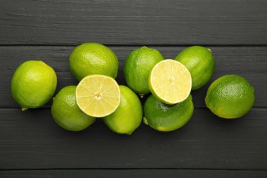 Siyah ahşap arka planda ikiye bölünmüş yeşil kireç. Üst görünüm