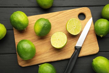 Siyah arka planda kesme tahtasında kesikli yeşil kireç. Üst görünüm