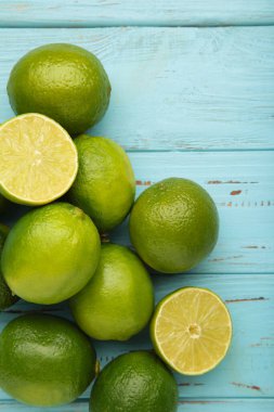 Mavi ahşap arka planda ikiye bölünmüş yeşil kireç. Üst görünüm