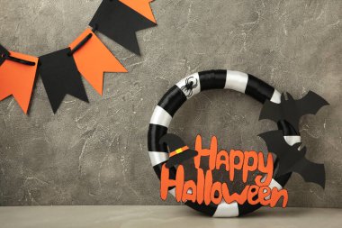 Gri arka planda hediyeli Cadılar Bayramı çelengi. Şükran Günü dekoru. Üst görünüm