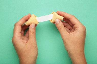 Elinde nefis fal kurabiyesi ve nane arkaplanda tahmini olan kağıt tutan kadın..