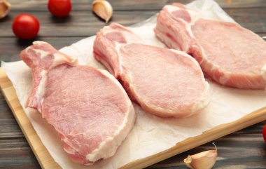 Kahverengi ahşap arka planda dilimlenmiş çiğ domuz eti. Üst görünüm