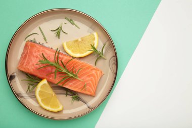 Kırmızı balık. Çiğ somon filetosu, biberiyeli ve limonlu, bej tabakta, naneli. Üst görünüm