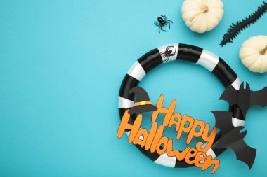 Mavi arka planda küçük balkabaklarıyla Cadılar Bayramı çelengi.