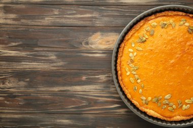 Kahverengi ahşap arka planda mini balkabaklı lezzetli balkabağı turtası. Şükran Günü