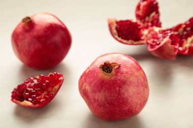 Hafif arkaplanda çekirdekleri olan bir nar ve yarım kesilmiş bir nar..