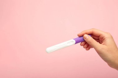 Pembe arka plandaki yeni hamilelik testi. Sağlık hizmeti konsepti. Üst görünüm