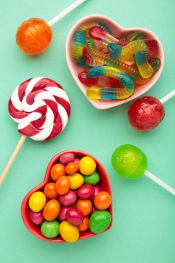 Mor arkaplanda farklı tipte şekerler, kopyalama alanı. Renkli doğum günü partisi geçmişi.