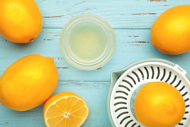 Mavi ahşap arka planda sıkma ve limon suyu. Üst görünüm