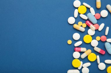 Mavi arka planda çeşitli renkli haplar. Üst görünüm