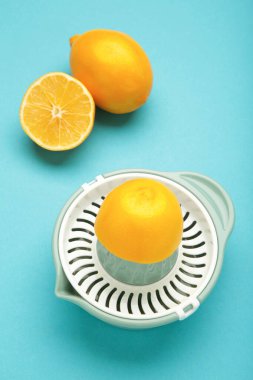 Mavi arka planda sıkma ve limon. Dikey fotoğraf. Üst görünüm