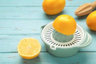 Mavi ahşap arka planda sıkma ve limon. Üst görünüm