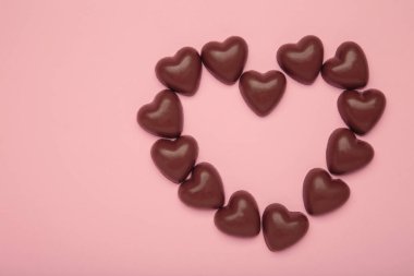 Kırmızı çikolatalı tatlılar pembe arka plandaki kalp gibidir. Sevgililer Günü konsepti. Üst görünüm