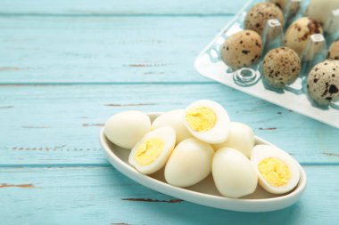 Mavi ahşap arka planda haşlanmış bıldırcın yumurtaları. Üst görünüm