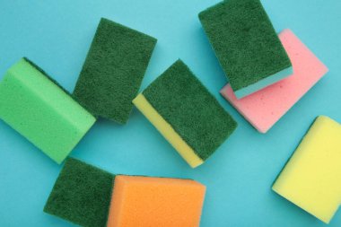 Mavi arka planda bulaşık yıkama süngeri. Üst görünüm