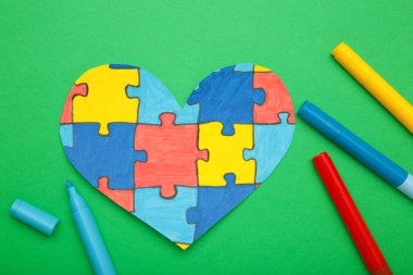 Dünya Otizm Farkındalık Günü, yeşil arka planda kalbi olan akıl sağlığı konsepti..