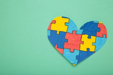 Dünya Otizm Farkındalık Günü, zihinsel sağlık konsepti ve temiz arka planda kalp bulmacası.