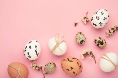 Paskalya yumurtalı kompozisyon pembe arka planda. Metin için boşluk