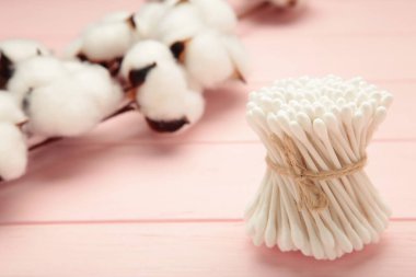 Pembe arka planda beyaz pamuk çizgileri. Çevre dostu. Kulaklar için hijyenik pamuk örnekleri.