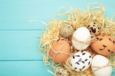 Mavi ahşap arka planda Paskalya yumurtaları olan kompozisyon. Metin için boşluk