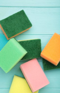 Mavi ahşap arka planda bulaşık yıkama süngeri. Üst görünüm