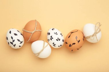 Bej arka planda Paskalya yumurtaları olan kompozisyon. Minimalizm