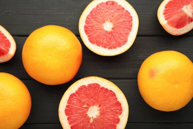Siyah ahşap arka planda taze çiğ greyfurt. Üst görünüm