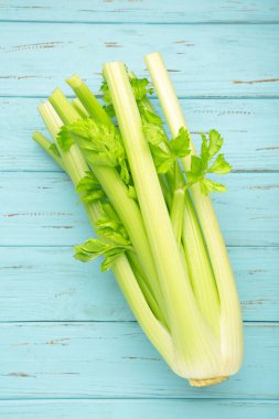 Mavi ahşap arka planda taze kereviz. Üst görünüm